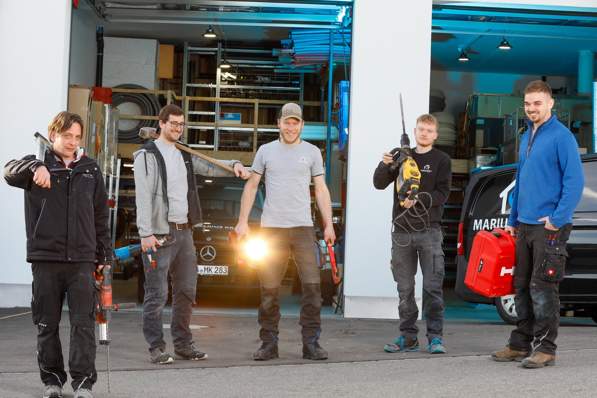 Team von Marius Kraut Heizung Sanitär Klimatechnik GmbH im Gegenlicht vor der Werkstatt