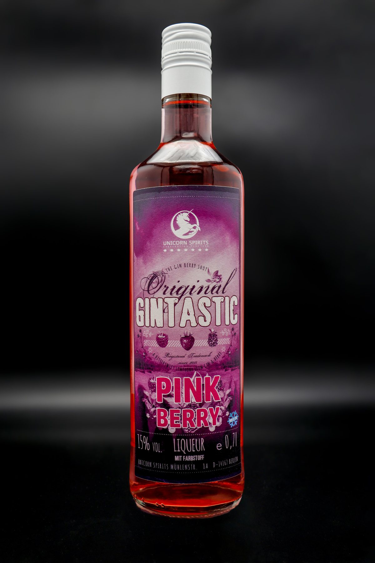 Spirituosenflasche 'Pink Berry' vor schwarzem Hintergrund