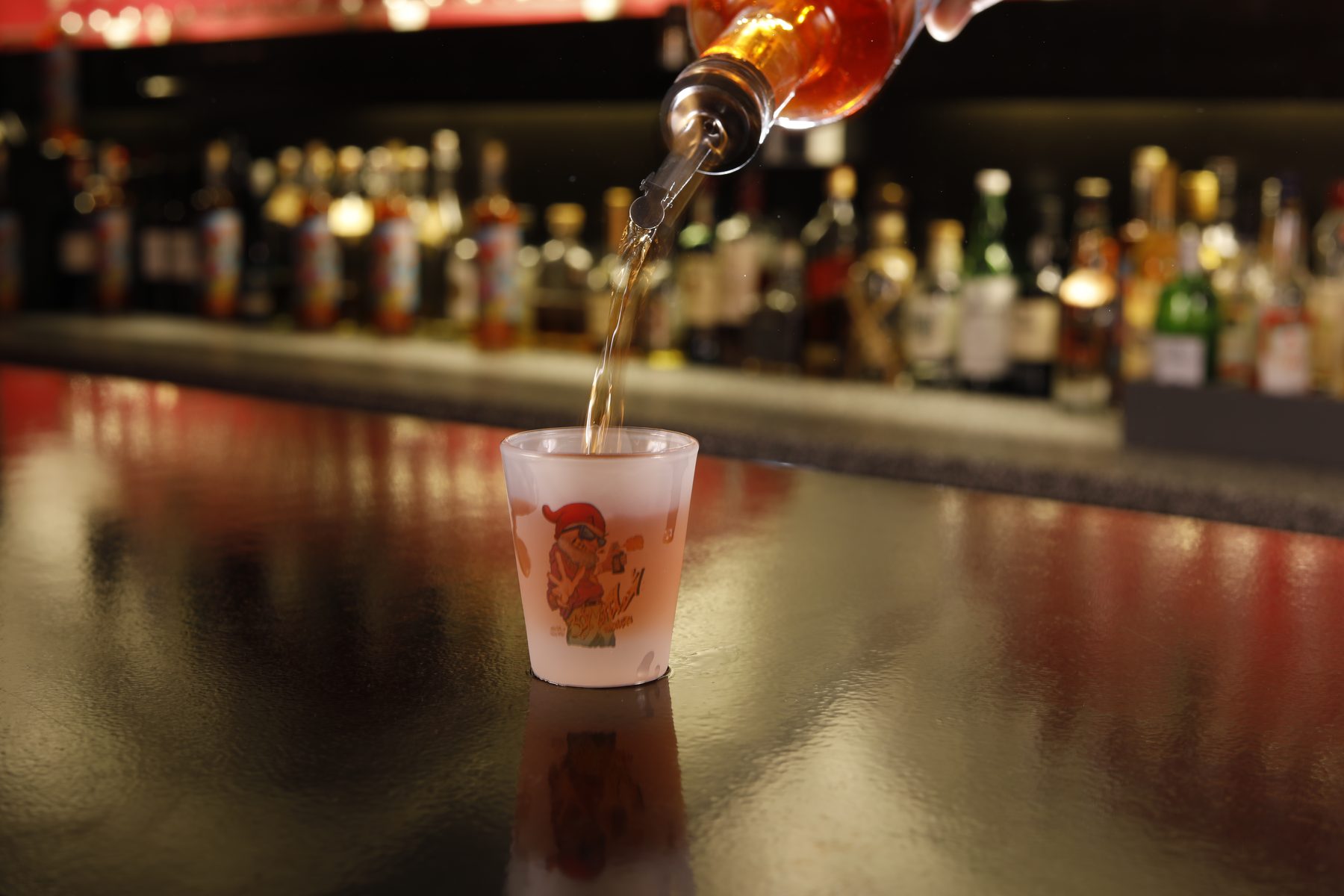 Dramatischer Pour-Shot aus niedrigem Winkel in ein Bar-Glas