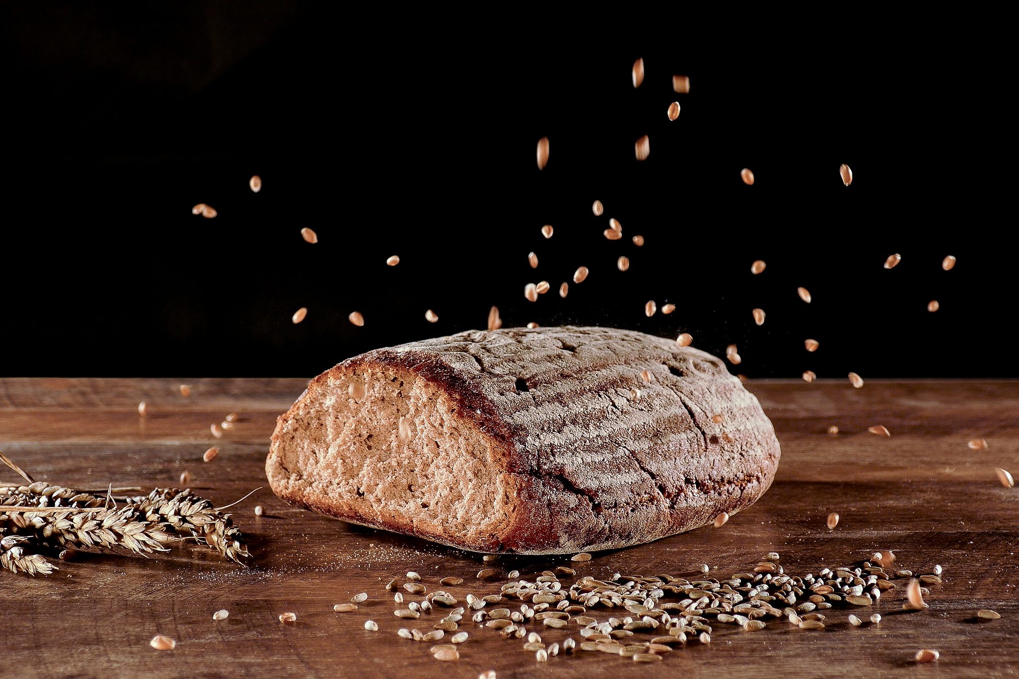 Freigestelltes Brot mit fliegenden Getreidekörnern