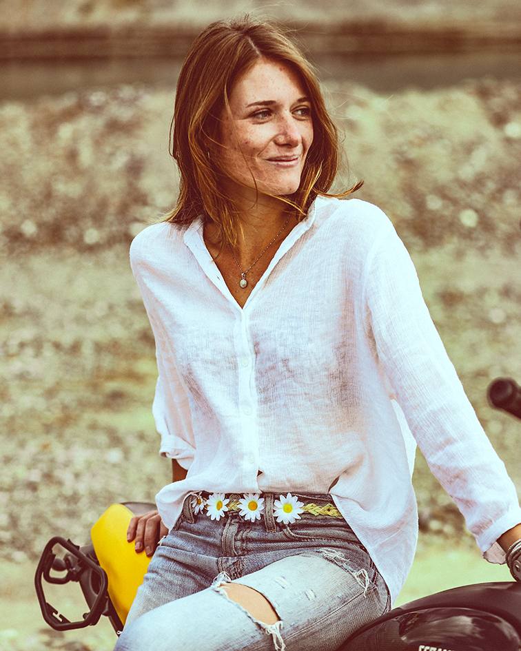 Editorial: Frau in weißer Bluse auf einem Motorrad